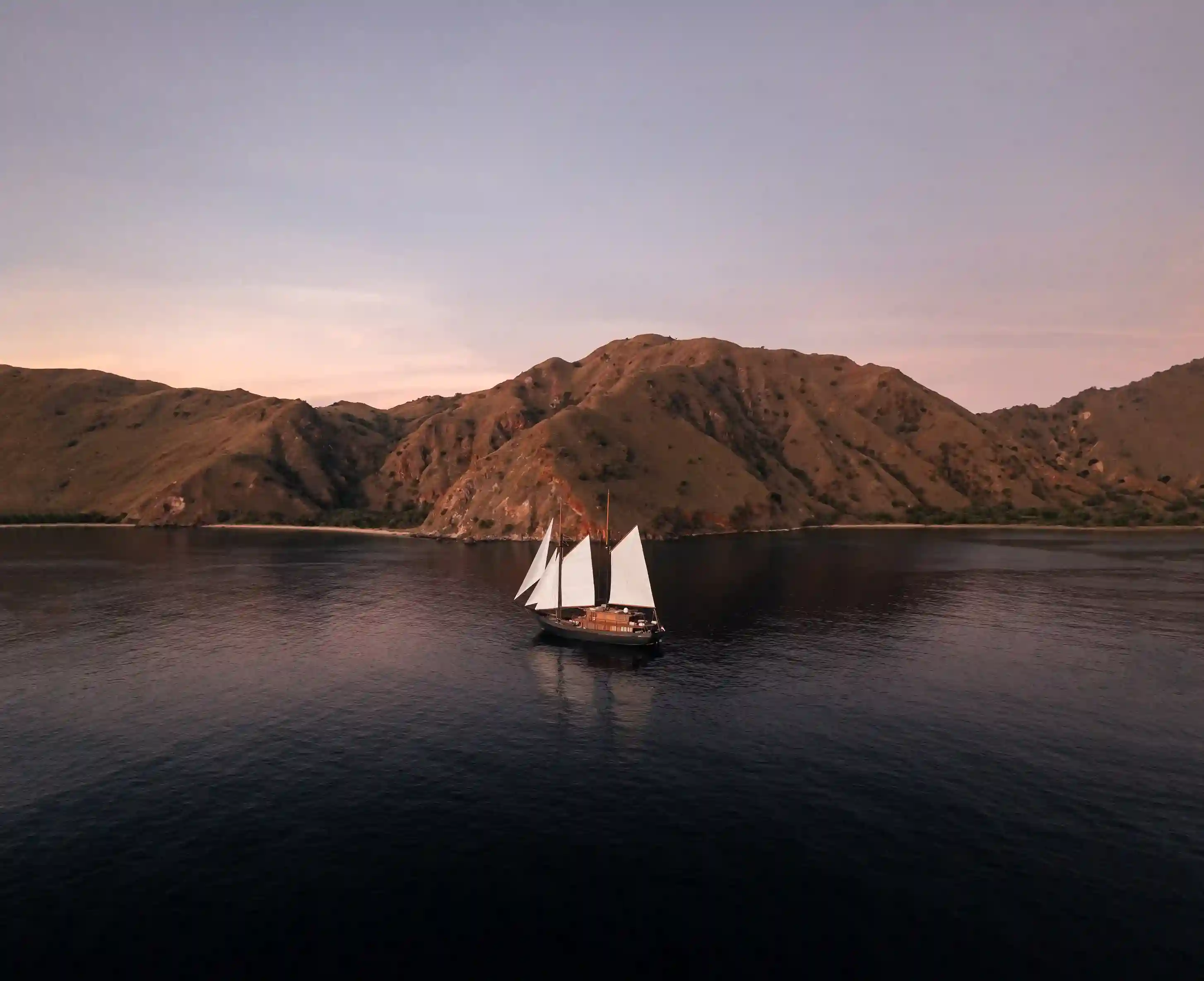 Boats moored in Labuan Bajo harbour at dusk
